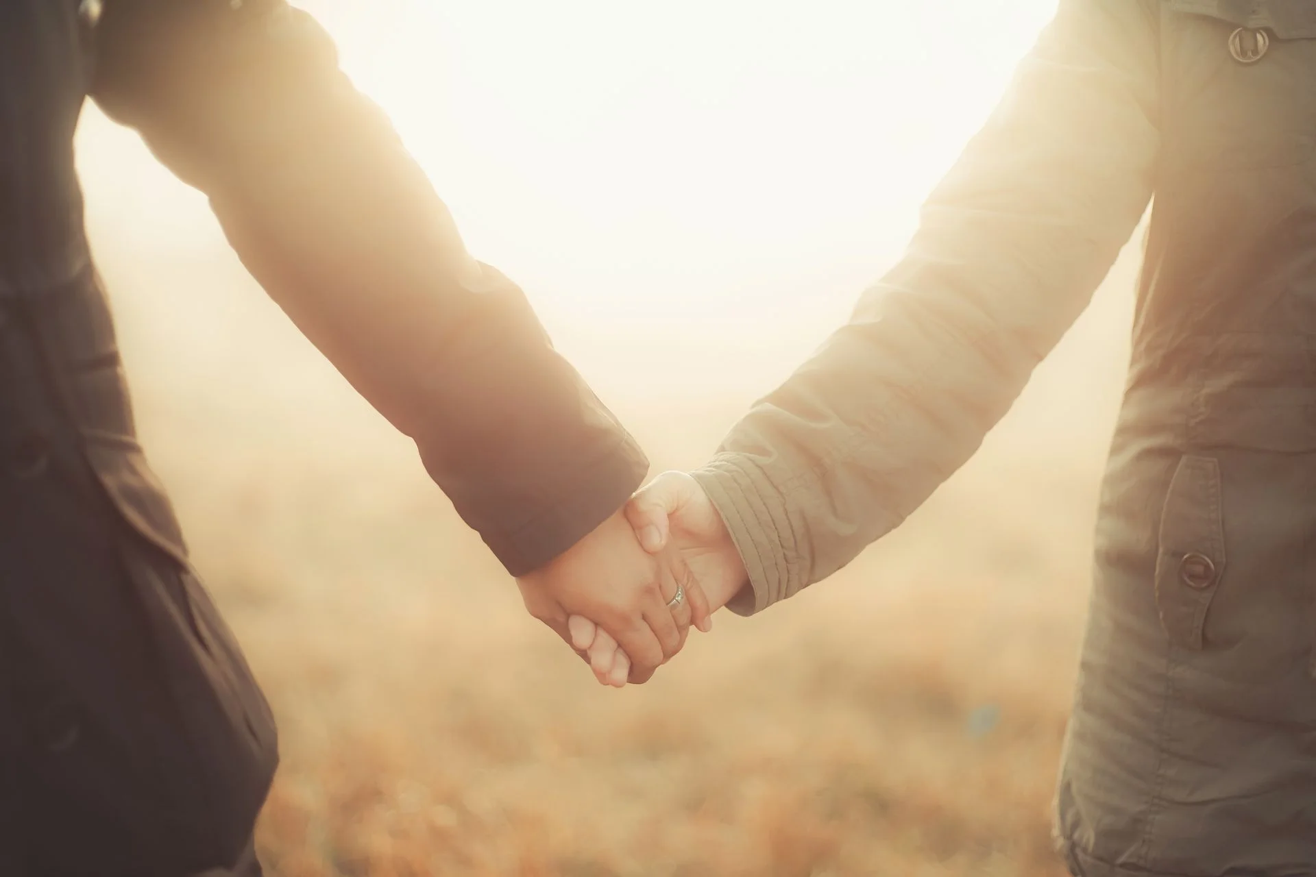 Two partners holding hands outdoors — illustrative photo