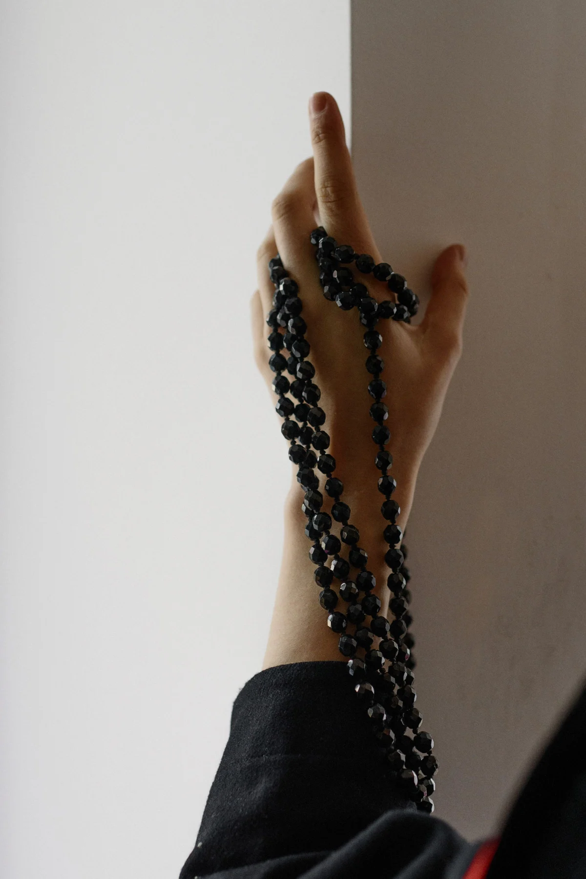 A hand holding prayer beads — an illustration of reflection