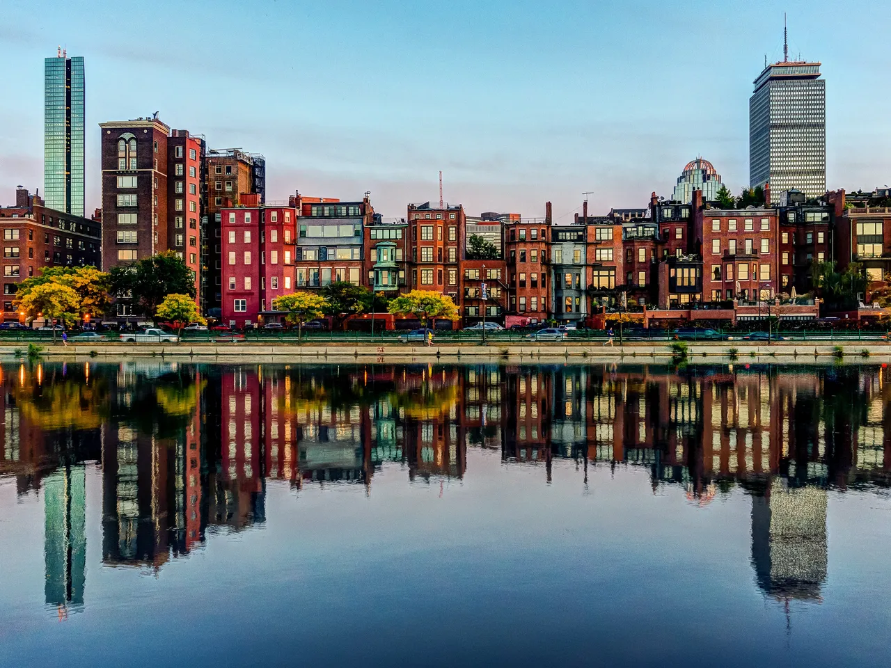 Back Bay’s brick row houses and the Prudential and John Hancock towers mirrored in calm water along the Charles River Esplanade, in Boston