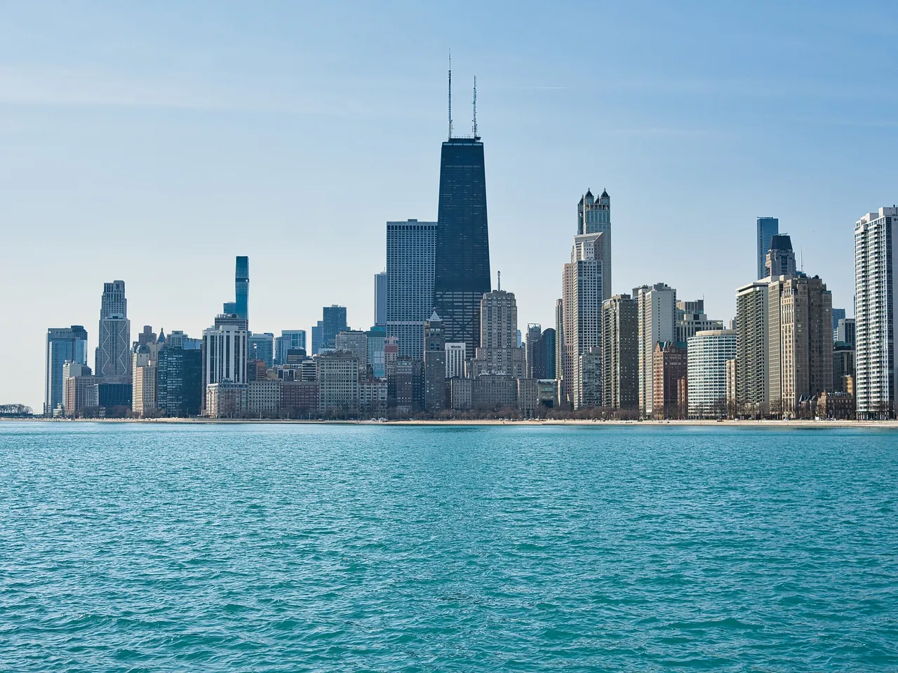 The Chicago skyline above the turquoise water of Lake Michigan, seen from the North Avenue Beach pier