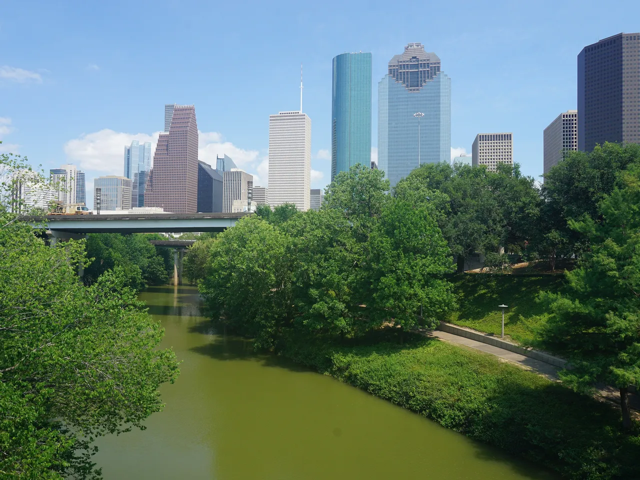 Downtown Houston’s towers rising above Buffalo Bayou and the trees of Buffalo Bayou Park