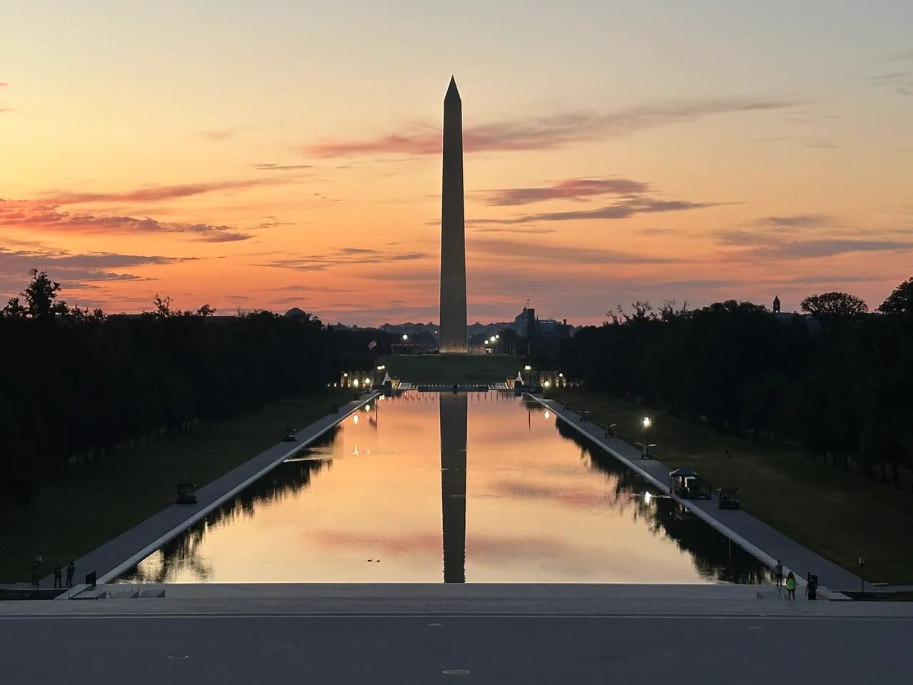 The Washington Monument and its reflection in the Lincoln Memorial Reflecting Pool under an orange sky, in Washington, DC